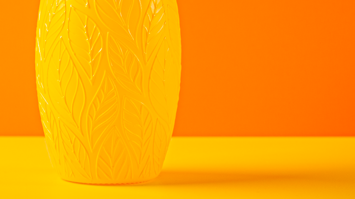 Yellow textured vase on a matching yellow surface with an orange background myrlèmon lemon myrtle digestif bottle suited to classic mixed drinks